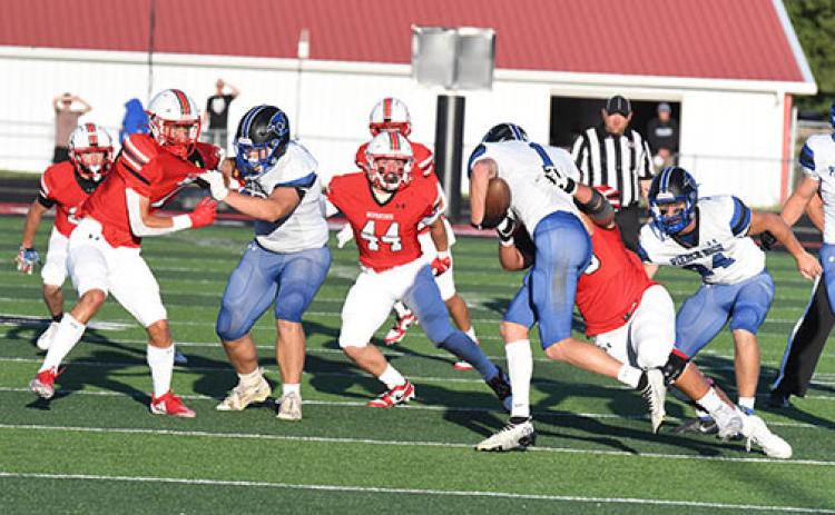 The sun shone brightly as the game began on a picture-perfect night for the season opener, a contest the Huskies dropped to Pierce, 41-28. Aurora defenders move in here to stop Brenden Bolling for no gain.