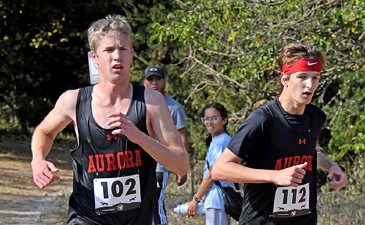 Charlie Evans (left) and Jayden Slagle race side by side throughout the Crete course at Doane University. Evans ran second in the boys race with Slagle placing fourth.