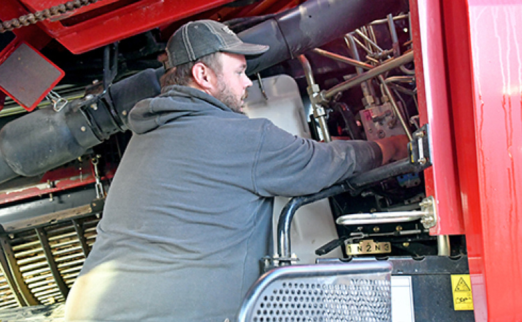 Josh Roehrs, a 2013 Hampton graduate, is a mechanic at Grosshans International while still getting his hands dirty on the farm.