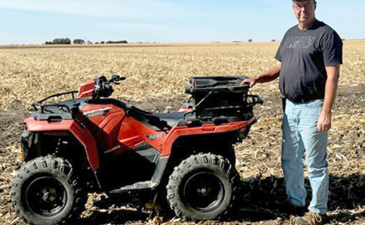 Independent agronomist and seed sales representative Mike Gruener stands by one of the tools of his trade, a four-wheeler he uses to check on crops in the field.