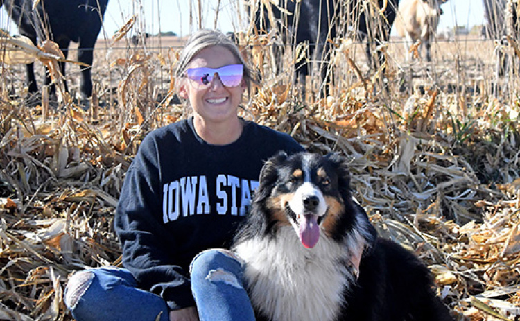 In addition to crop production, Sarah Jensen and her family take care of 150 head of cattle on their farm near Hampton. With Jensen is her Australian shepherd, Duke.