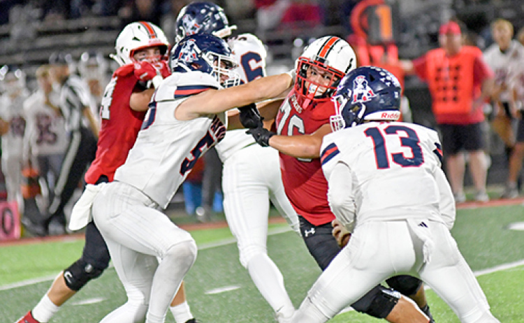 Aurora’s Jeryn McClain (76) beats his man and puts pressure on AC’s QB Jackson Sughroue late in the second half of the Huskies’ 21-7 win over the Patriots Friday.
