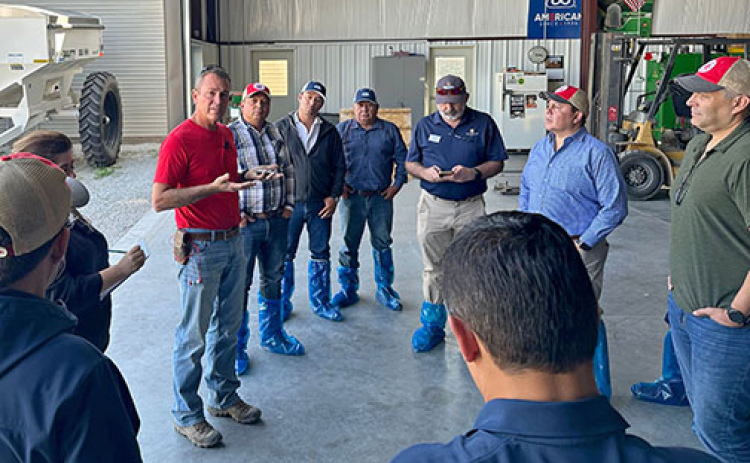 Hamilton County corn grower Nate Goertzen (left) talks with members of a Mexican trade mission group that visited his farm in October. The members of the team are wearing boot covers to avoid the risk of transporting contaminants from one country to another.