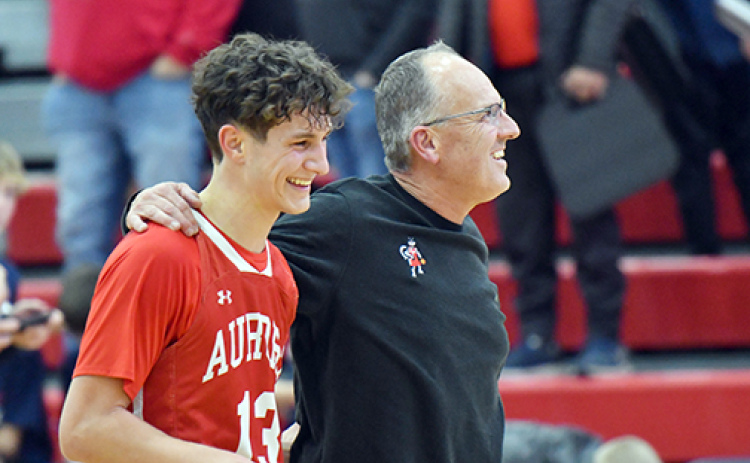Aurora senior Parker Smith (left) and coach Kevin Asher celebrate in the moments after Aurora’s 49-43 win at Adams Central Thursday, the 500th career win for the longtime mentor. Smith buried a pair of game-defining three-point shots in the fourth quarter.