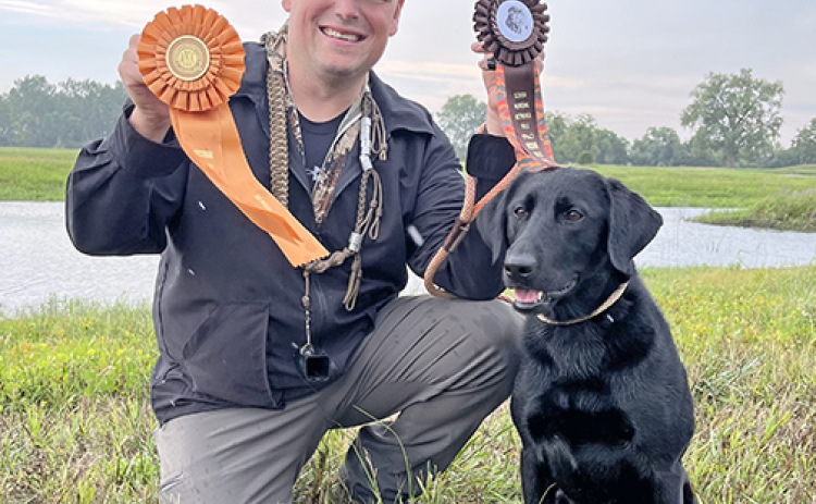 Zach Tesar and his dog, Sioux, pose for a photo after earning Senior hunting retrieving titles last summer.