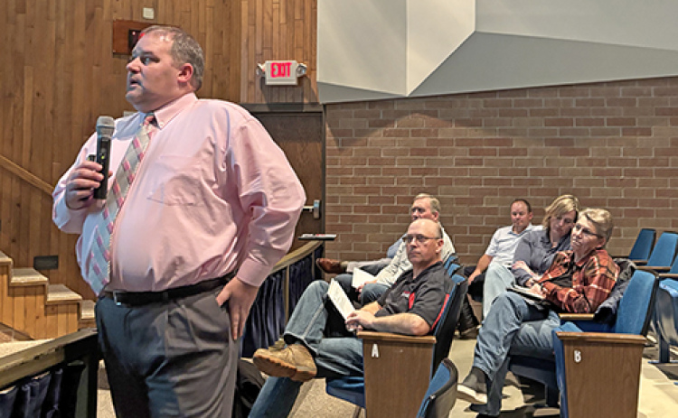Aurora Supt. Jody Phillips looks toward a large projection screen in the middle school theater while making a presentation about the district’s proposal to expand the preschool program. Looking on in the background are members of the Aurora School Board.
