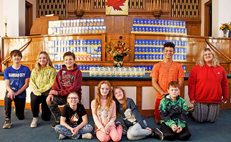Members of the combined Aurora First Christian Church/Presbyterian UCC Youth Group pose in front of the more than 200 boxes of macaroni and cheese they collected through their recent Mac & Cheese Challenge. Seated in front, from left, are Allyson Schmidt, Myra Williams, Megan Williams, Kale Williams; back row, Kyler White, Annabelle Manley, Marcus Skarniak, Chris Skarniak and Khloe Williams.
