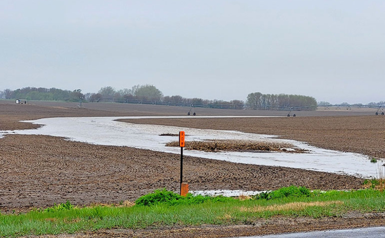 A waterway in a field west of Highway 14 near Marquette flows with muddy water in late April as more than four inches of overnight rain runs off.