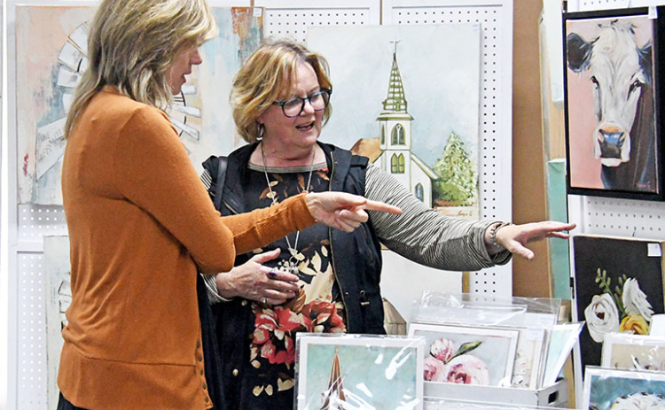 Artist Tonya Grosshans (left) talks about her realistic and abstract paintings with Art Walk patron Beverly Goertzen during the September event in downtown Aurora.
