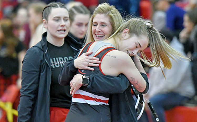 Aurora’s Caly Settles celebrates with coach Sheri Thompson after surviving the heartbreak round to officially qualify for the state wrestling championships in Omaha.