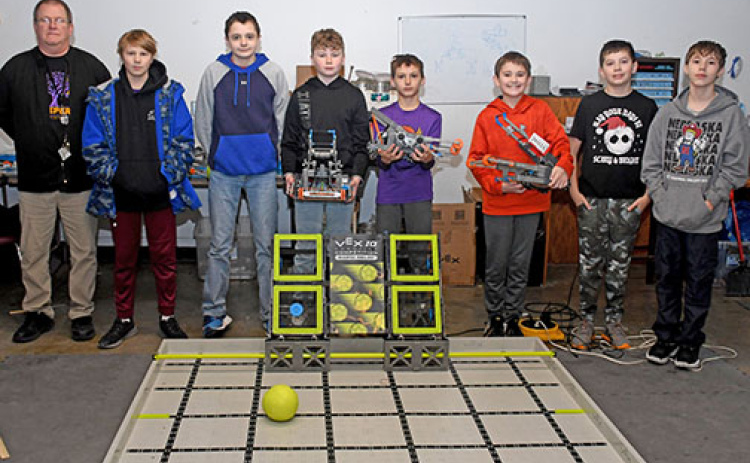 Members of the Hampton Elementary and Middle School robotics team pose for a picture with the robots they built by this year’s competition game. From left are team sponsor Gary Richards, Daniel White (7th grade), Ethan Litz (7th grade), Lawson Haberer (7th grade), Uriah Brooks (4th Grade), Deven Dose (6th Grade), Reis Stump (6th Grade) and Christopher Brooks (6th Grade). Not Pictured: Isaiah Venteicher (4th Grade), Camron Vandermate (7th Grade), Olivia Lemburg (7th Grade) and Samuel Venteicher (7th Grade).