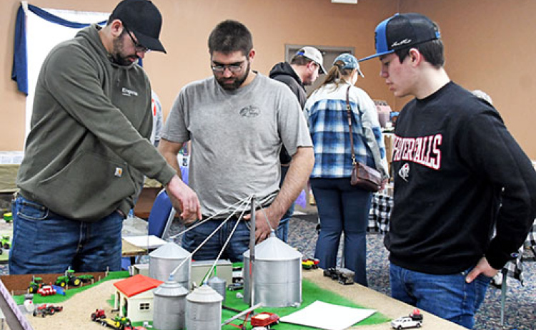 The Leadership Center hosted its first Farm Toy Show on Sunday with visitors and vendors coming from all over Nebraska eager to find antique farm toys in addition to dolls, games and other pop culture items offered at the show. Event co-organizer Chaz Boeder (right) showcases his farm toy model to brothers Jake and Garrett Byerly.