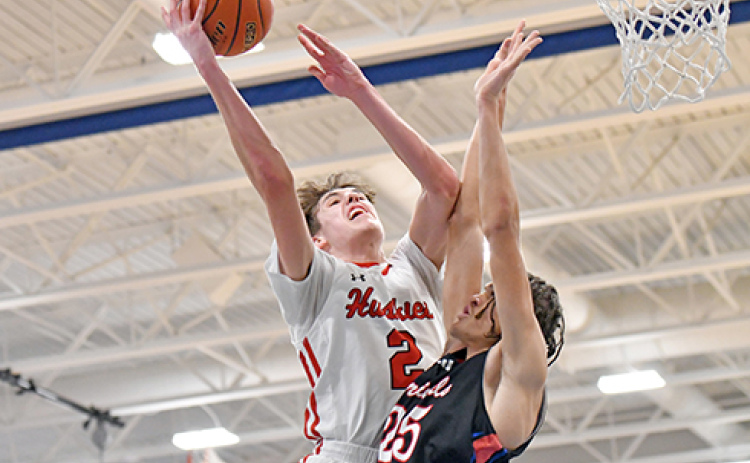 Booker Scheierman finishes with contact at the rim during Aurora’s 57-48 win over Crete in Saturday’s Central Conference final.
