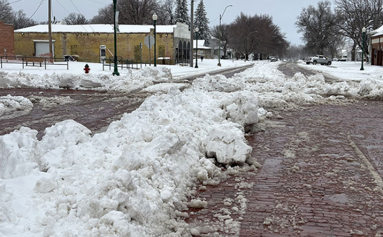 City crews have begun clearing streets in Aurora, though piles of wet, heavy snow remain in the center of some streets, making travel difficult.