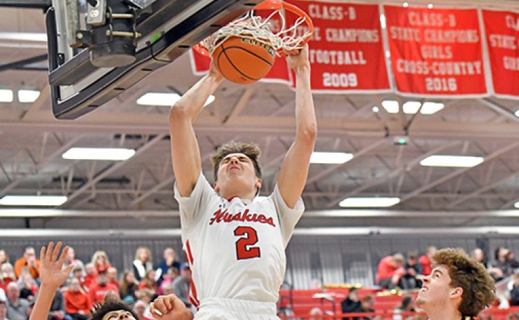 Booker Scheierman throws down one of his two first-quarter dunks that brought the home crowd to life. However, Gretna East survived the early onslaught from Aurora and came back to defeat the Huskies 50-40 in Monday’s B-8 district final.