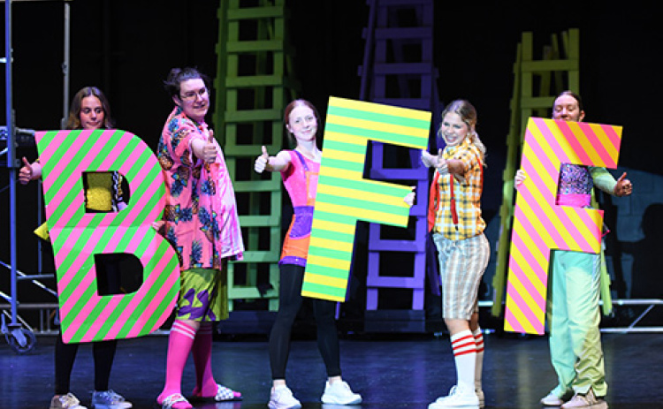 Jacob Inman, as Patrick Star, and Eva Yllescas (center right), pose together after singing “BFF.” Holding the “BFF” signs are from left: Piper Oswald, Hannah Janda and Makenna Oswald.