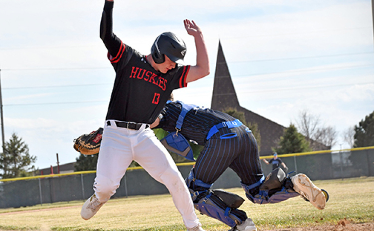 Jack Spiehs dances around a tag at the plate to score an early run for the Huskies.