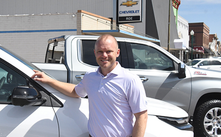 Jason Roe stands in front of the Roe Chevrolet dealership in downtown Aurora, where plans have been announced to expand the service department.