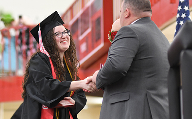Aurora senior Jorja Pohlmeier, who was one of two class speakers on Sunday, is congratulated by Supt. Jody Phillips after receiving her diploma.