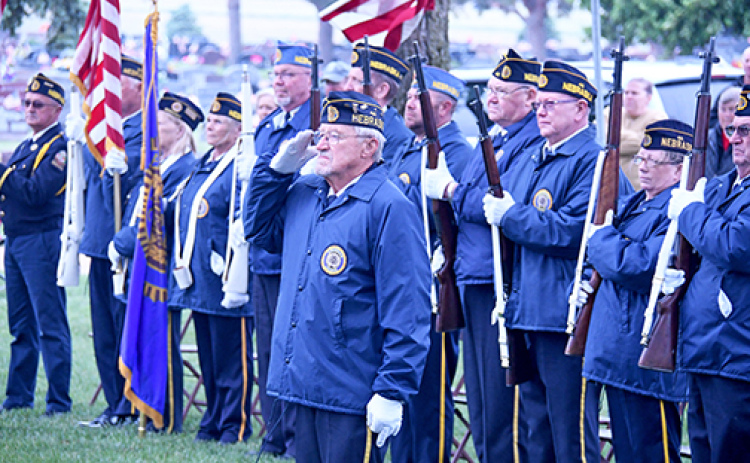 Ron Elge stands and salutes the presentation of colors during the Memorial Day service at the Aurora Cemetery on Monday.