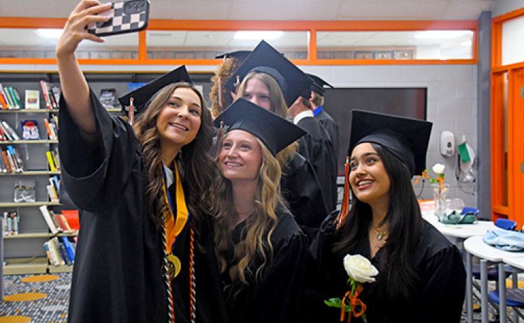 Prior to the graduation ceremony, graduating senior Sophie Faltys (left) takes a selfie with her classmates. Featured in the selfie includes, from left: Jordan Margritz, Giovanna Nogara. In back: Kaitlyn Kothe.