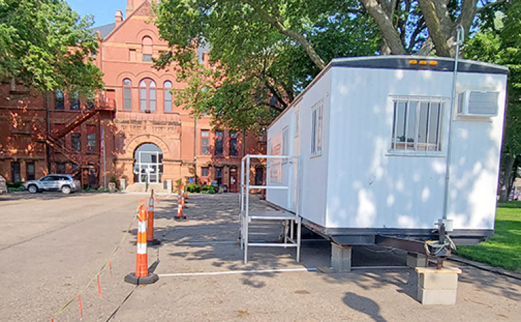 Traffic cones and a construction trailer mark the north side of the courthouse parking lot which will be used to store equipment and materials during the exterior renovation of the building starting on June 16. The courthouse steps will be replaced first but the ground floor entrance will remain open throughout the project. The restrooms will also be accessible during A’ROR’N Days at the end of the month.