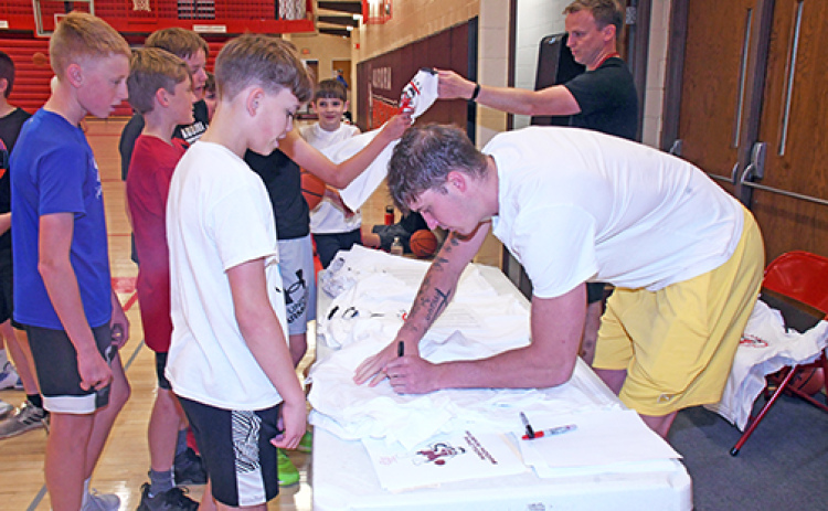 Baylor Scheierman signs autographs for boys participating in the Husky Hoops Factory summer camp earlier this month in the very same gym where he started his basketball career. Camp t-shirts were handed out and Scheierman signed both the t-shirts and the boys’ athletic shoes.