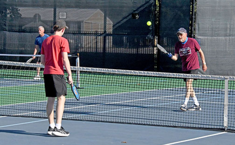 Dr. John Wilcox (right) and his grandson, Shawn Morris, both of Aurora, warm up before the start of the multi-generational pickleball tournament on Friday evening.