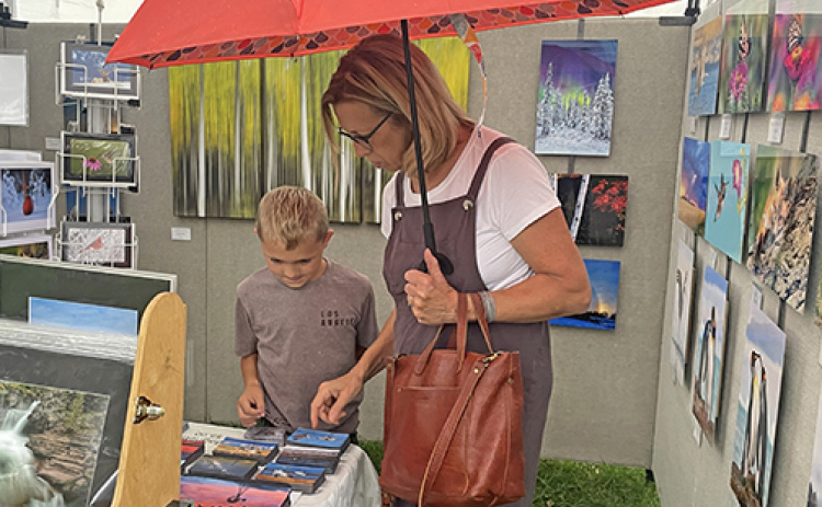 Lee Olsen and his grandmother Betty browse through several photos taken by Rick Rasmussen of Platter River Photography during Sunday’s Art Walk Aurora.