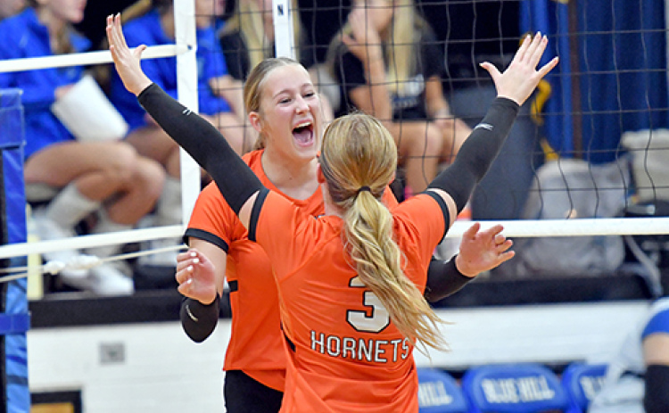 Giltner’s Peyton Schutt (behind) celebrates with Avery Reeson after one of Schutt’s 12 kills in a 3-0 win over Blue Hill Friday night.