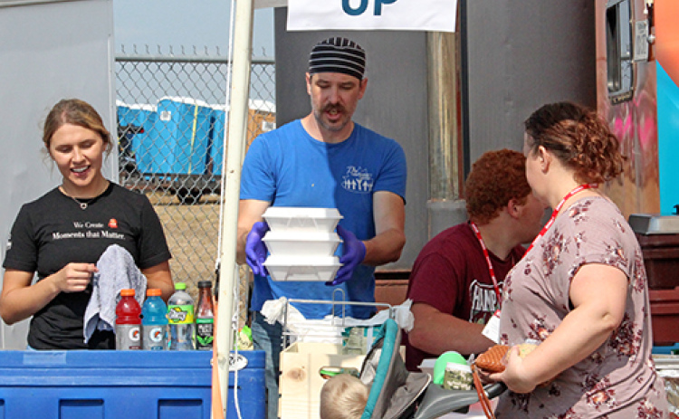 The Leadership Center Executive Chef John Boeder, center, works the serving line at TLC's prime rib sandwich booth at Husker Harvest Days.