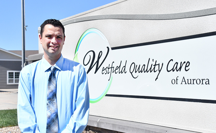New administrator Chad Thompson stands by the sign in front of the Westfield Quality Care facility.