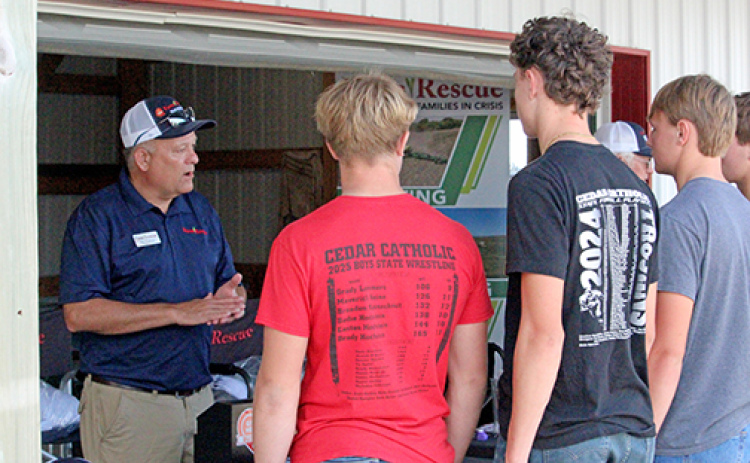 Tim Sullivan (left), executive director of Farm Rescue, visits with FFA students from Hartington at the organization’s booth at Husker Harvest Days. The non-profit, based in Jamestown, N.D., has hundreds of volunteers across 10 states ready to help farmers during a time of crisis with planting or harvest.