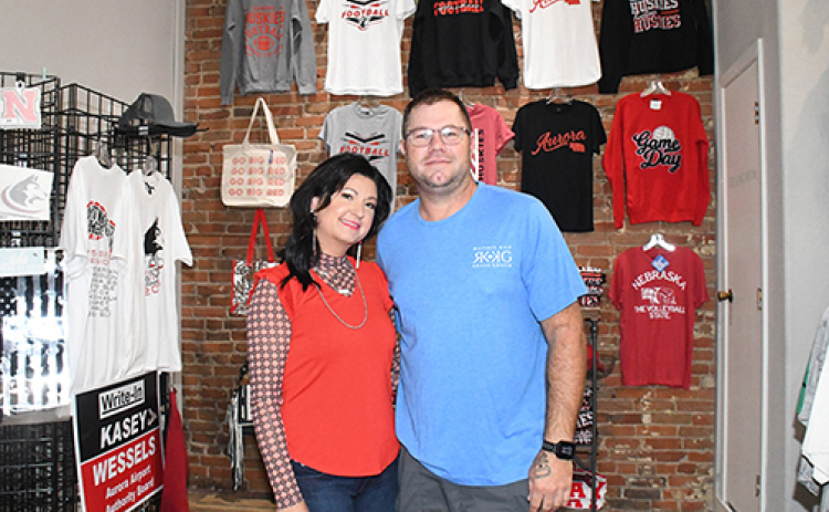 Karla Ericksen and Kris Willcock stand in the display area of their new business, which features the combined creativity of Ruthie Kay Boutique and Krash Grafix.