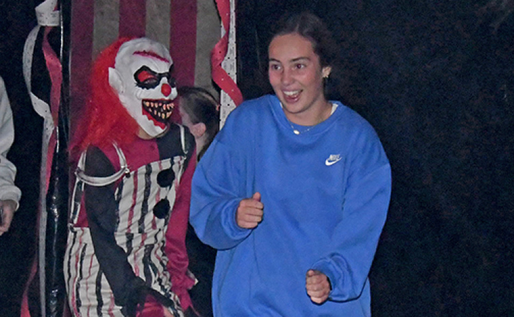 Avery Miller makes a quick escape from the Wolff Building as a clown (Brenden Zucco) chases after her Sunday night. Over 480 people visited the Hamilton County Haunted Fairgrounds during the opening weekend with many braving the maze twice or three times.