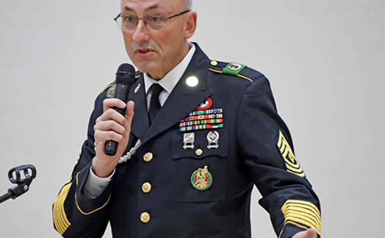 Speaker Chris Hochstetler explained the meaning of the arrangment of medals on his Army uniform to the audience at the Veterans Day program at Hampton last Tuesday.