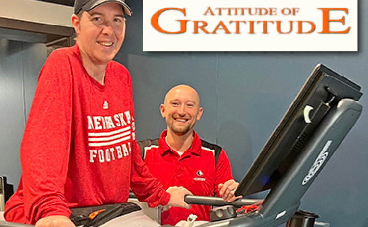 Tyler Nunnenkamp works out on a physical therapy machine at Memorial Rehab in Aurora. With him is his good friend and physical therapist, Kyle Shaffer.