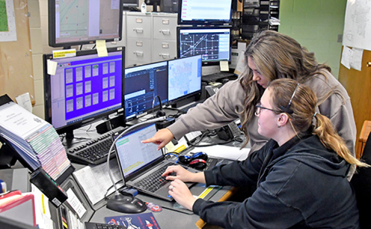 Hamilton County 911 dispatchers Melissa Barry (standing) and Sidney Fochtman have spent numerous hours being trained on how to use the RapidSOS software which allows dispatchers to receive vital medical information when a caller who has elected to share that information calls using a smart phone.