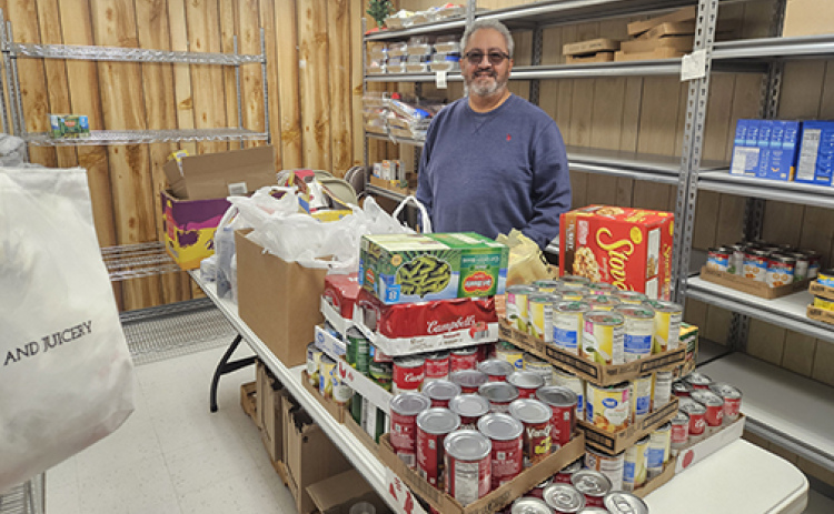 Rudy Flores, pastor of the Messiah Lutheran Church in Aurora, helped deliver a timely donation of 500 pounds of food last week, one of many local food drives anticipated in the next few weeks.