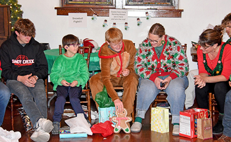 Exchange students open white elephant gifts at their Christmas party on Dec. 7