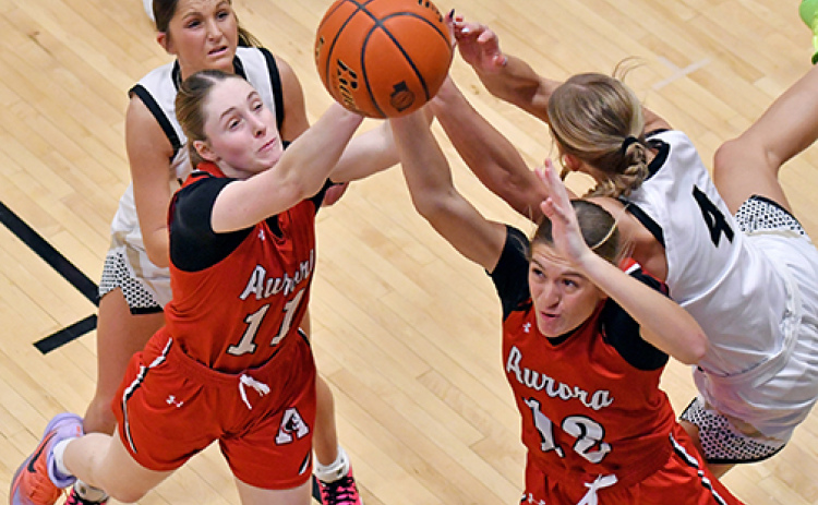 Aurora’s Kaitlyn Staehr (11) and Maddie Ramaekers (12) battle for an offensive rebound between two Northwest defenders during the Huskies’ 52-48 win over the Vikings Saturday, improving its record to 4-2 on the season.