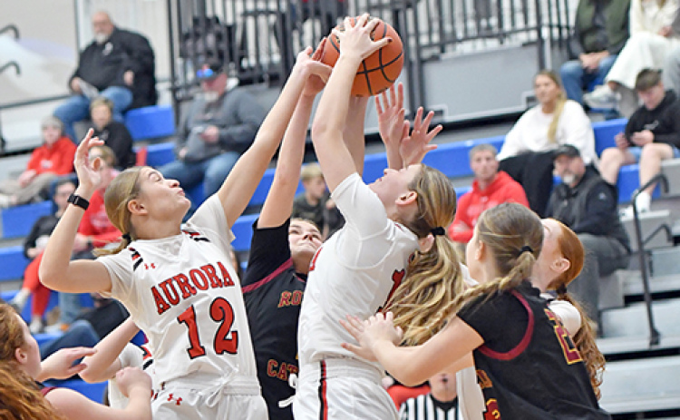 Aurora’s Maddie Ramaekers (12) and Paisley Bartek (15) are among a cluster battling for a rebound during Monday’s 68-41 win over Omaha Roncalli.