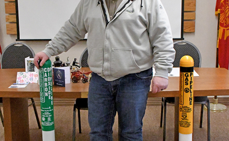 Scott Barry, a damage prevention supervisor for Tallgrass, stands between two pipeline marker pillars he brought to a meeting of the county Local Emergency Planning Committee (LEPC)last  Wednesday. The marker on the left is green and marks a line that carries carbon dioxide and the marker on the right is yellow which represents the presence of a natural gas pipeline.