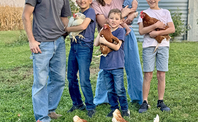 The Bolis family poses for a picture with the laying hens they acquired so their children could go into the egg business. From left are Kevin, Jay, Sally, Emmett, Adalie and João.