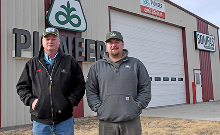 Pioneer seed representative Greg Bonifas, left, and his son Grant, stand out front of their facility north of Aurora along Highway 14. Bonifas celebrated his 25th anniversary with the company last year and is helping Pioneer celebrate its 100th anniversary in 2026.