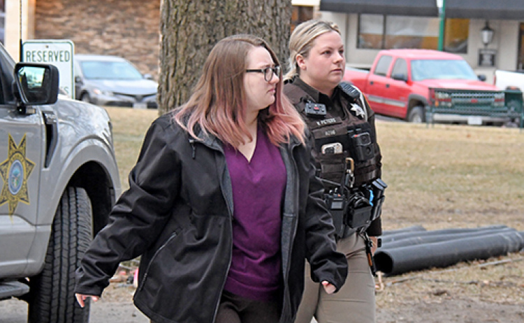 Tiffany Cure is escorted to trial Thursday morning by a deputy sheriff.