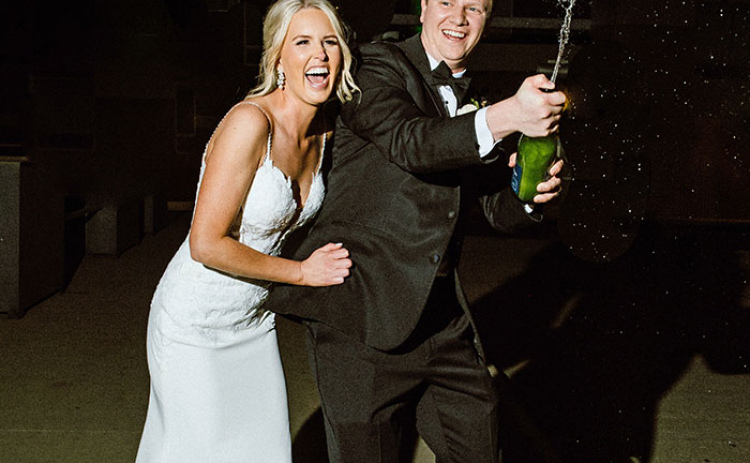 This photo was taken by Laura Oswald during a wedding in downtown Omaha with Laura Oswald using a newer flash setup to add a different dynamic in capturing the couple as the champange sprays.