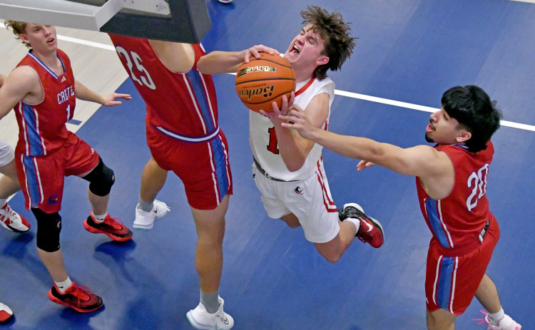 Canon Allen goes up strong in the paint surrounded by Crete defenders, part of his 19-point performance in Aurora's 52-41 win over the Cardinals.