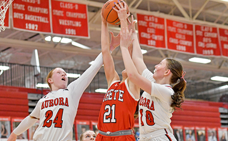 Aurora’s Evelyn Kraus (24) and Kenna Merrihew (10) battle for an offensive rebound sandwiched with Crete’s Kassidy Egge.