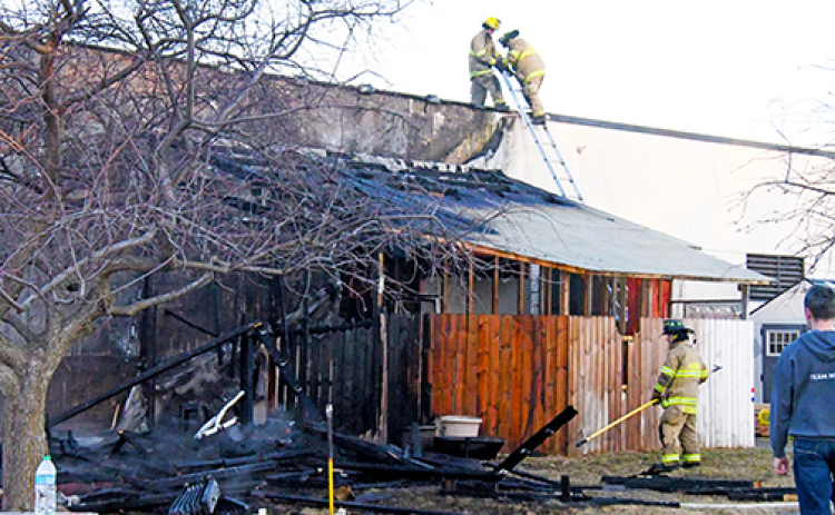 Aurora firefighters check the roof of the Edgerton Explorit Center after an early morning fire on Friday destroyed the raptor enclosure attached to the back of the building.